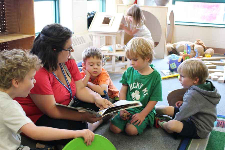 educator reading a book to preschoolers